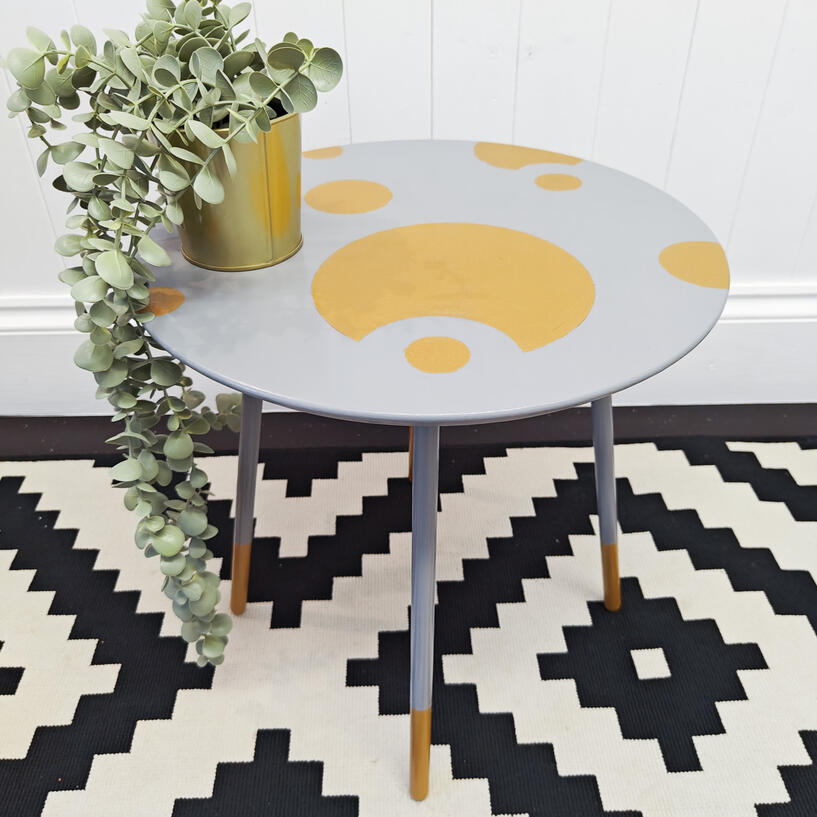 40cm circular side table with three legs, table is in light grey with gold circles on the top, the legs are light grey with gold tips
